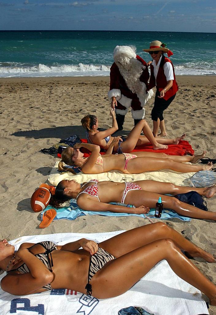 Santa Claus walks Fort Lauderdale beach in 2001 and spreads cheer to the sunbathers.