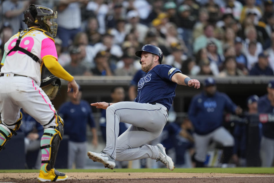 Tampa Bay Rays' Luke Raley, right, slides home, scoring from second base off an RBI single by Randy Arozarena as San Diego Padres catcher Gary Sanchez waits for the throw during the fourth inning of a baseball game Friday, June 16, 2023, in San Diego. (AP Photo/Gregory Bull)