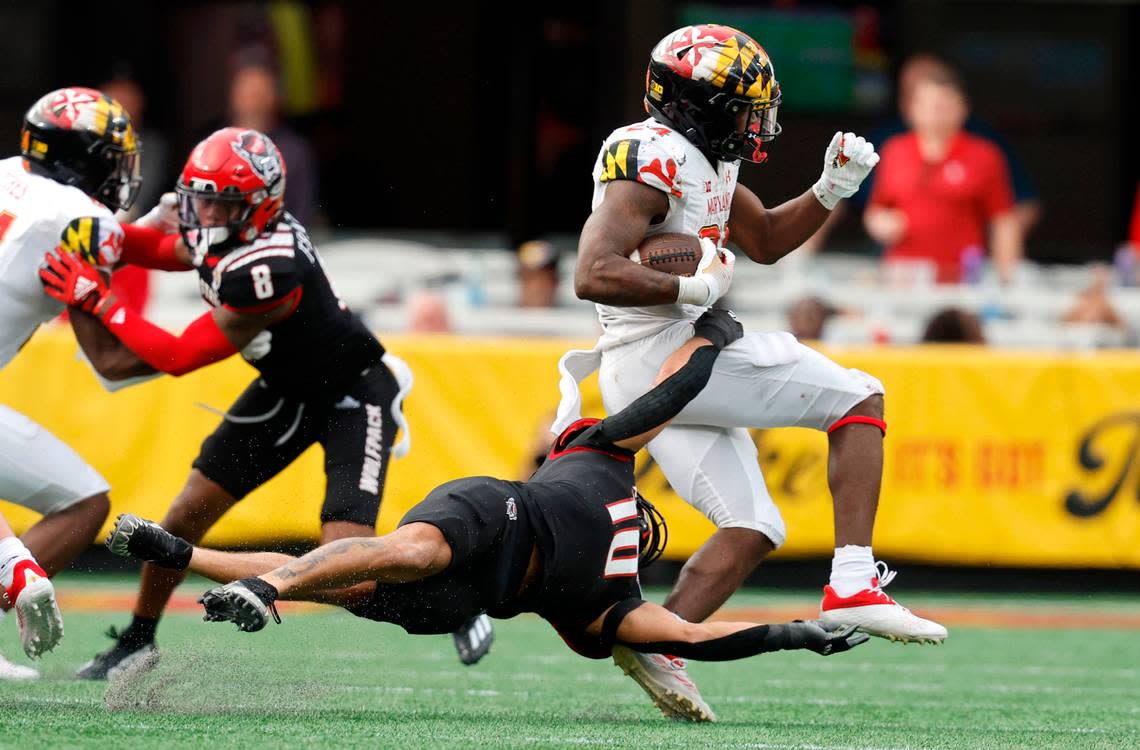 N.C. State safety Tanner Ingle (10) tries to bring down Maryland running back Roman Hemby (24) during the second half of Maryland’s 16-12 victory over N.C. State in the Duke’s Mayo Bowl at Bank of America Stadium in Charlotte, N.C., Friday, Dec. 30, 2022.