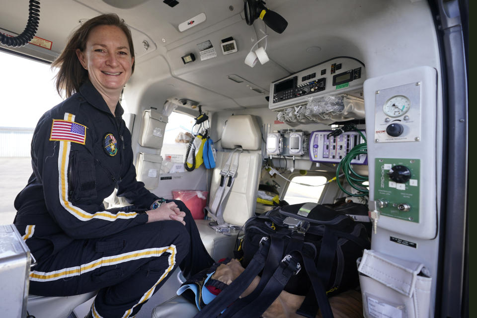 Air ambulance flight paramedic, Rita Krenz, poses inside the helicopter that she works in Weyers Cave, Va., Monday, March 15, 2021. Krenz started a fund-raising campaign that brought in more than $18,000 for the charity that has helped RIP Medical Debt forgive the debt of more than 900 people so far. (AP Photo/Steve Helber)