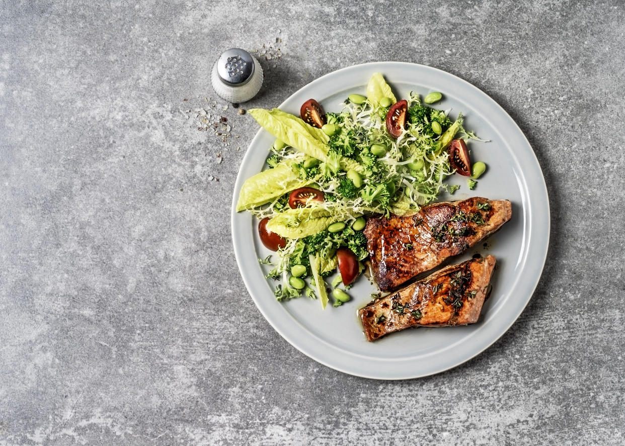 A plate of pan seared salmon with fresh salad. (Photo: Getty Images)