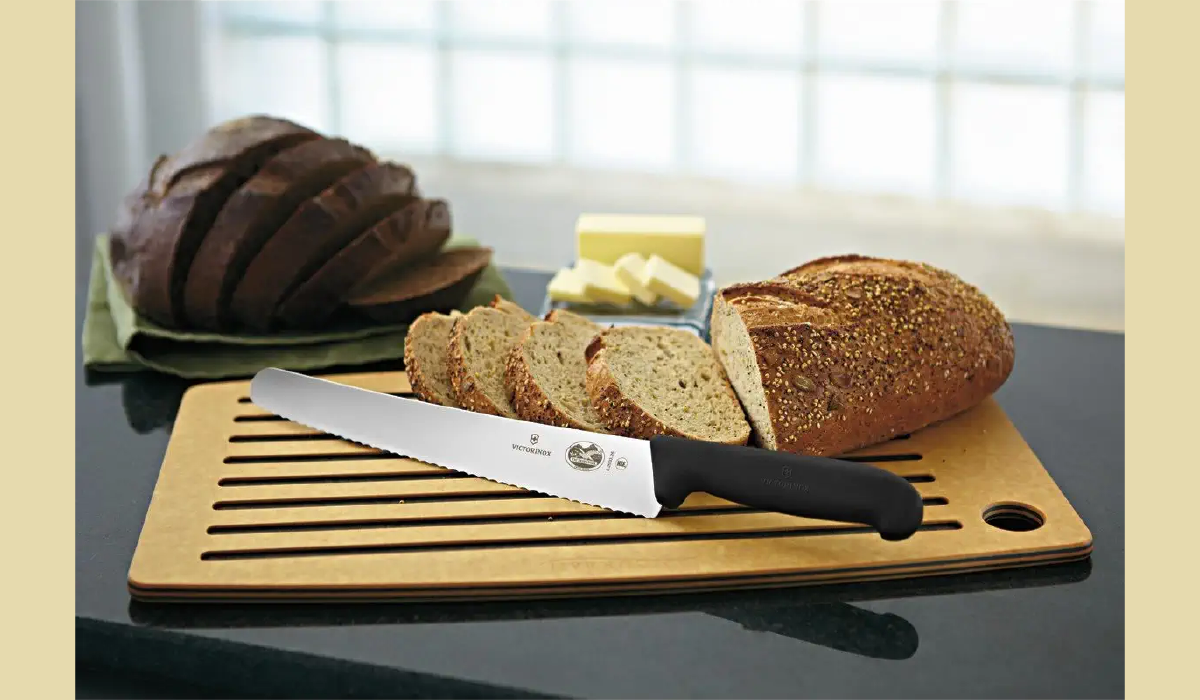 Bread knife with sliced bread on cutting board