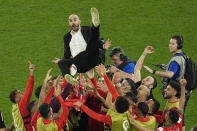 Morocco's head coach Walid Regragui is thrown in the air at the end of the World Cup round of 16 soccer match between Morocco and Spain, at the Education City Stadium in Al Rayyan, Qatar, Tuesday, Dec. 6, 2022. (AP Photo/Abbie Parr)