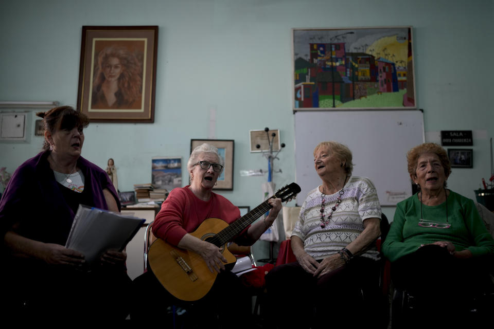 Ana Falcone plays the guitar during a music class at the Caballito and Villa Crespo, a recreational day center for retirees, in Buenos Aires, Argentina, Thursday, April 13, 2023. Falcone says her retirement pension is no longer enough and that for women like her, who have the misfortune of being widowed, it is helpful to also receive a second pension for widows, but that she would prefer her husband be alive. (AP Photo/Natacha Pisarenko)