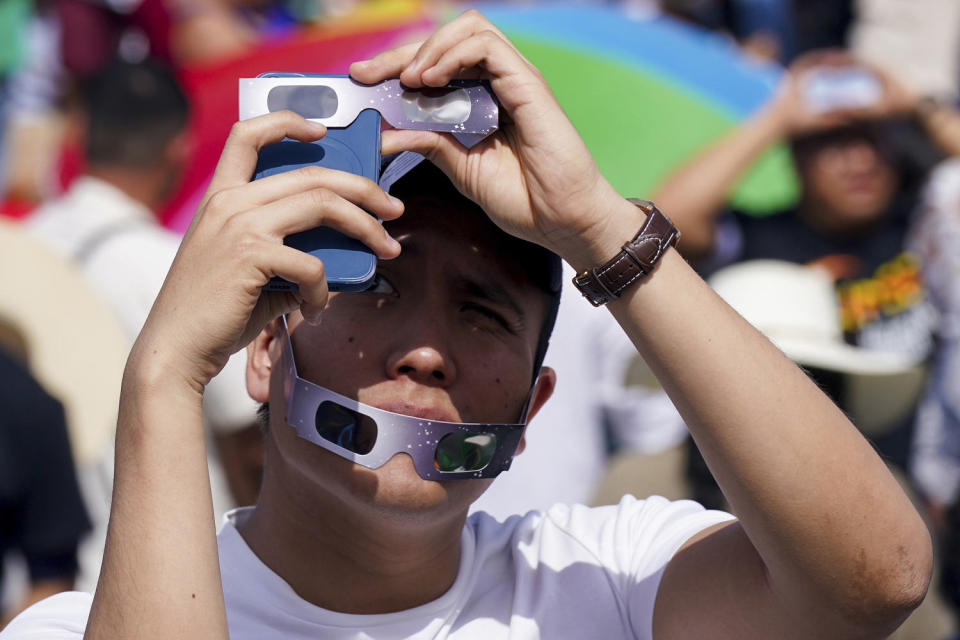 A man takes a photo of the total solar eclipse in Mazatlán, Mexico. (Fernando Llano / AP)