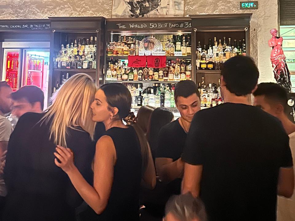 people in a crowded bar in athens greece