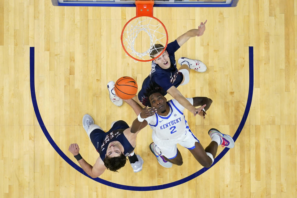 Kentucky's Aaron Bradshaw, center, battles for a rebound against Pennsylvania's Andrew Laczkowski, top, and Nick Spinoso during the second half of an NCAA college basketball game, Saturday, Dec. 9, 2023, in Philadelphia. (AP Photo/Matt Slocum)