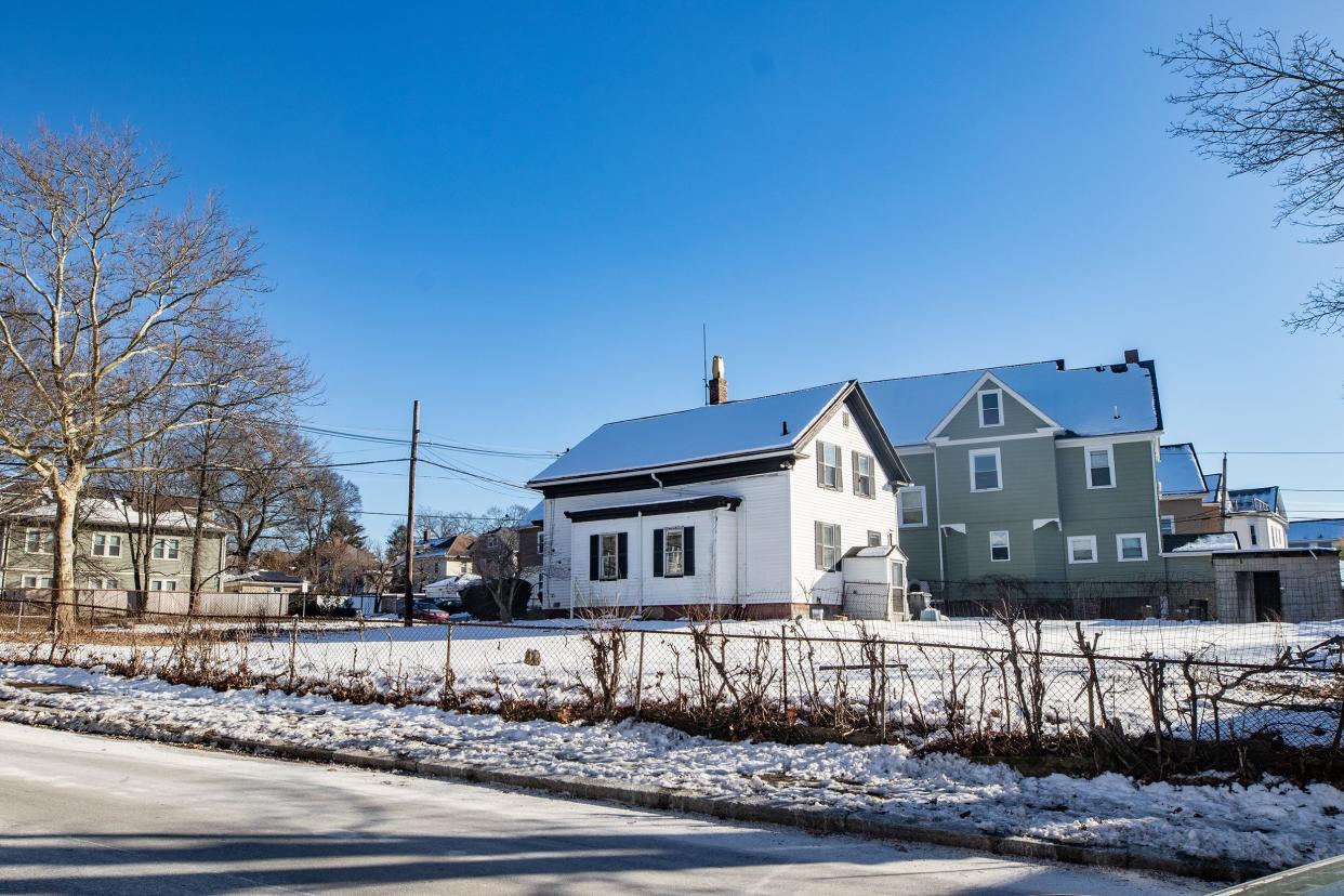 The empty lot and white house at 103 Evergreen St. in Providence's Mount Hope neighborhood are the proposed site of an apartment building.