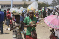 A woman and her daughter sell refreshments at a busy market on the outskirts of the capital Harare, Monday, Nov, 15, 2021. When the coronavirus first emerged last year, health officials feared the pandemic would sweep across Africa, killing millions and destroying the continent’s fragile health systems. Although it’s still unclear what COVID-19’s ultimate toll will be, that catastrophic scenario has yet to materialize in Zimbabwe or much of Africa. (AP Photo/Tsvangirayi Mukwazhi)