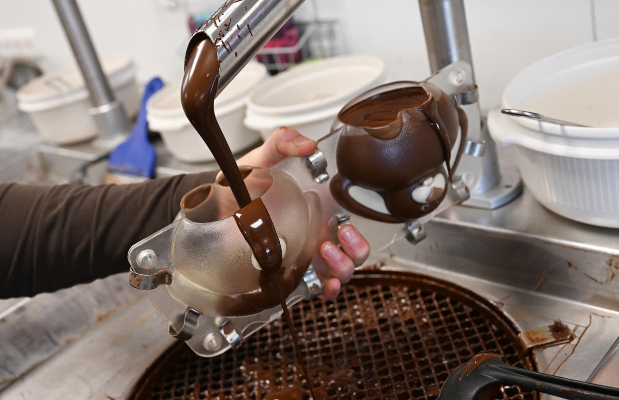 chocolate PRODUCTION - 30 March 2023, Bavaria, Garmisch-Partenkirchen: A confectioner pours chocolate into a 