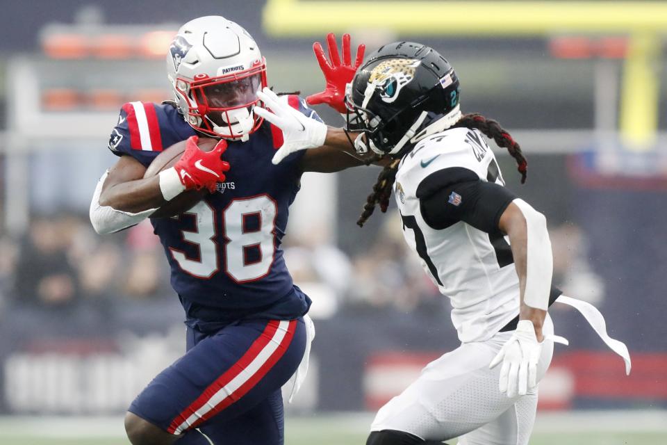 New England Patriots running back Rhamondre Stevenson (38) tries to break free from Jacksonville Jaguars cornerback Chris Claybrooks, right, during the first half of an NFL football game, Sunday, Jan. 2, 2022, in Foxborough, Mass. (AP Photo/Paul Connors)