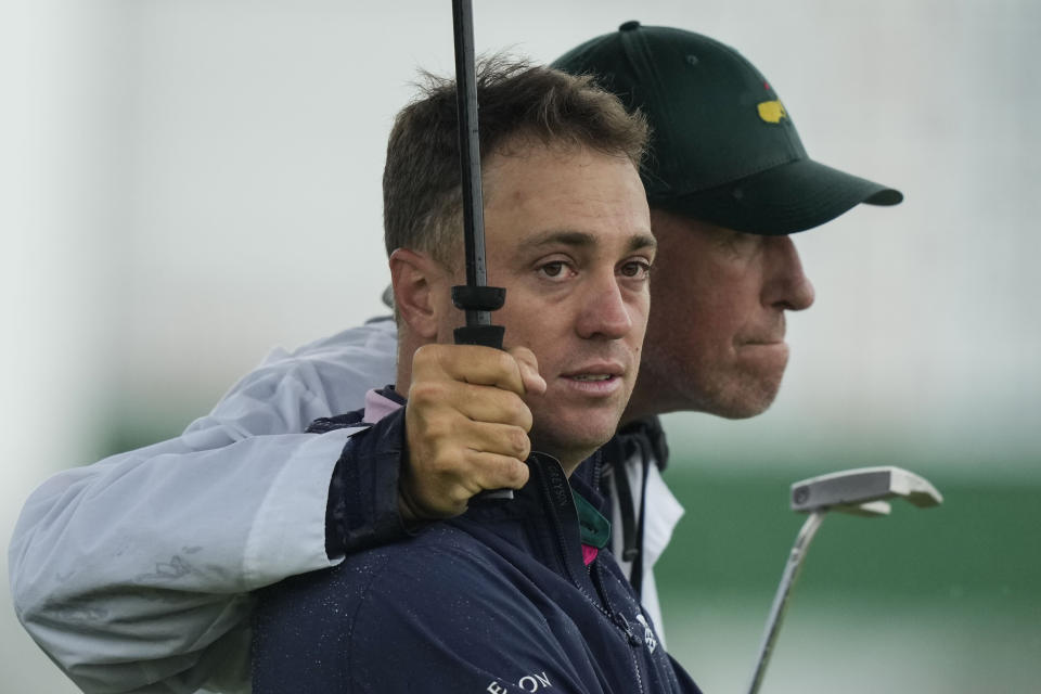 Justin Thomas and his caddie Jim Mackay wait on the 18th hole during the weather delayed second round of the Masters golf tournament at Augusta National Golf Club on Saturday, April 8, 2023, in Augusta, Ga. (AP Photo/Charlie Riedel)