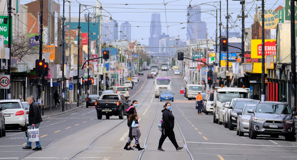 Pedestrians cross Sydney Road in Coburg, Melbourne, Friday, May 28, 2021. Victoria has reported four new locally acquired coronavirus cases on the first day of a seven-day lockdown, taking the total number of infections to 30. Source: AAP