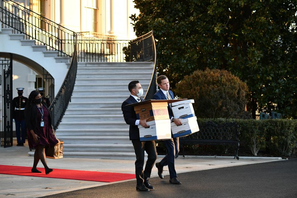 Aides carry boxes to Marine One before president Donald Trump and wife Melania Trump departed from the White House on Trump's final day in office on Jan. 20, 2021, in Washington, D.C.