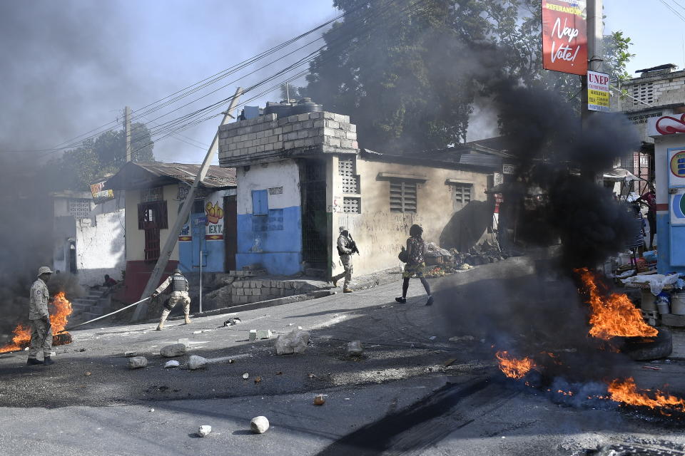 Tires burn after being set on fire by protesters upset with growing violence as police patrol and try to put out the flames and clear the road for vehicles in the Lalue neighborhood of Port-au-Prince, Haiti, Wednesday, July 14, 2021. Haitian President Jovenel Moise was assassinated on July 7. (AP Photo/Matias Delacroix)