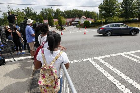 Members of the public watch from the street at the funeral of Kristina Bobbi Brown, the only child of singer Whitney Houston at Saint James United Methodist Church in Alpharetta, Georgia, August 1, 2015. REUTERS/Tami Chappell