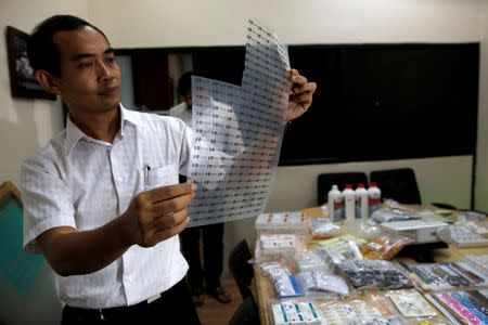 An officer from the National Police Criminal Investigation department shows printing material along with evidence confiscated from raids linked to fake vaccines production and distribution in a crackdown carried out in the capital Jakarta and neighbouring Banten and West Java Provinces, at national police headquarters in Jakarta, Indonesia June 27, 2016. REUTERS/Darren Whiteside