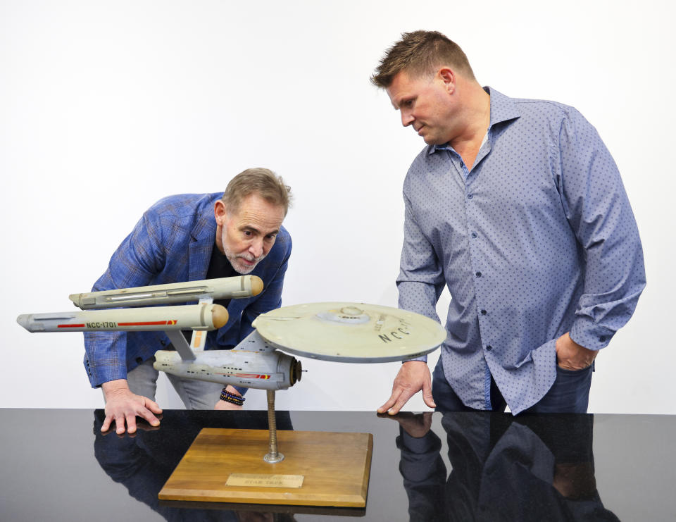 Joe Maddalena, executive vice president of Heritage Auctions, left, and Eugene “Rod” Roddenberry, the son of “Star Trek” creator Gene Roddenberry, view the recently recovered first model of the USS Enterprise at Heritage Auctions in Los Angeles, April 13, 2024. The model — used in the original “Star Trek” television series — has been returned to Eugene, decades after it went missing in the 1970s. (Josh David Jordan/Heritage Auctions via AP)