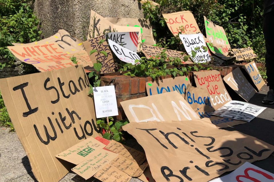Placards left by protesters at the spot on Monks Park Avenue in Bristol where a NHS worker was seriously injured in a racially-aggravated incident.PA