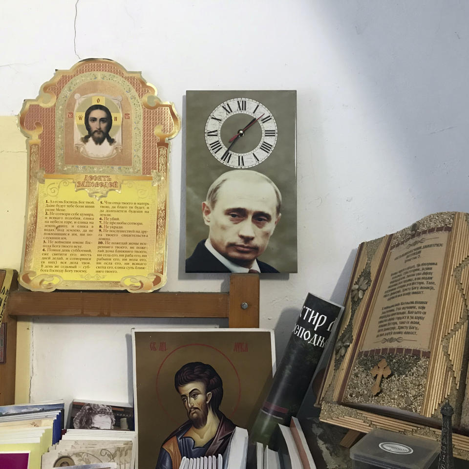 In this photo taken Friday, Jan. 11, 2019, a wall clock with a picture of the Russian President Vladimir Putin is placed in an office in the Serbian Orthodox Remeta Monastery in the village of Velika Remeta in northwestern Serbia. Traditionally close ties between Russia and Serbia have recently been visibly revived as Putin stepped up efforts to restore Moscow's influence in the former communist countries of Eastern Europe. (AP Photo/Marko Drobnjakovic)
