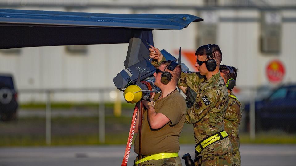 Attaching an AIM-9X to an F-35A wing pylon. AIM-120 AMRAAMs are only carried internally in the F-35. <em>Jamie Hunter</em>