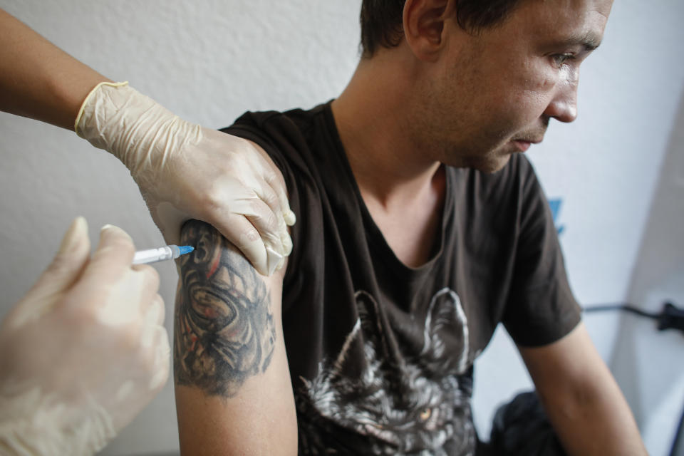 Stanislav, a homeless man gets a shot of the one-dose Sputnik Light vaccine at a mobile vaccination station in St. Petersburg, Russia, Wednesday, Aug. 11, 2021. Russia has faced a surge in new infections blamed on the growing prevalence of the more contagious delta variant and low vaccine uptake. (AP Photo/Elena Ignatyeva)