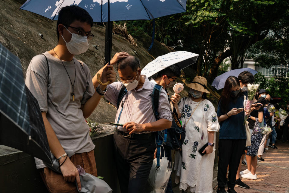 People wait in line to pay tribute to Queen Elizabeth II outside the British Consulate in Hong Kong, Friday, Sept. 16, 2022. In Britain, thousands of mourners waited for hours Thursday in a line that stretched for almost 5 miles (8 kilometers) across London for the chance to spend a few minutes filing past Queen Elizabeth II's coffin while she lies in state. (AP Photo/Anthony Kwan)