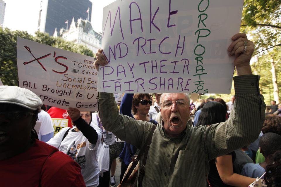 Members of the Occupy Wall St movement protest on 5th Avenue while marching through the upper east side of New York