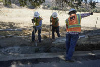 A Pacific Gas and Electric crew works on burying power lines in Vacaville, Calif., Wednesday, Oct. 11, 2023. PG&E wants to bury many of its power lines in areas threatened by wildfires. (AP Photo/Jeff Chiu)