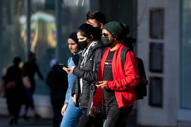 People walk along Granville Street in Vancouver. 