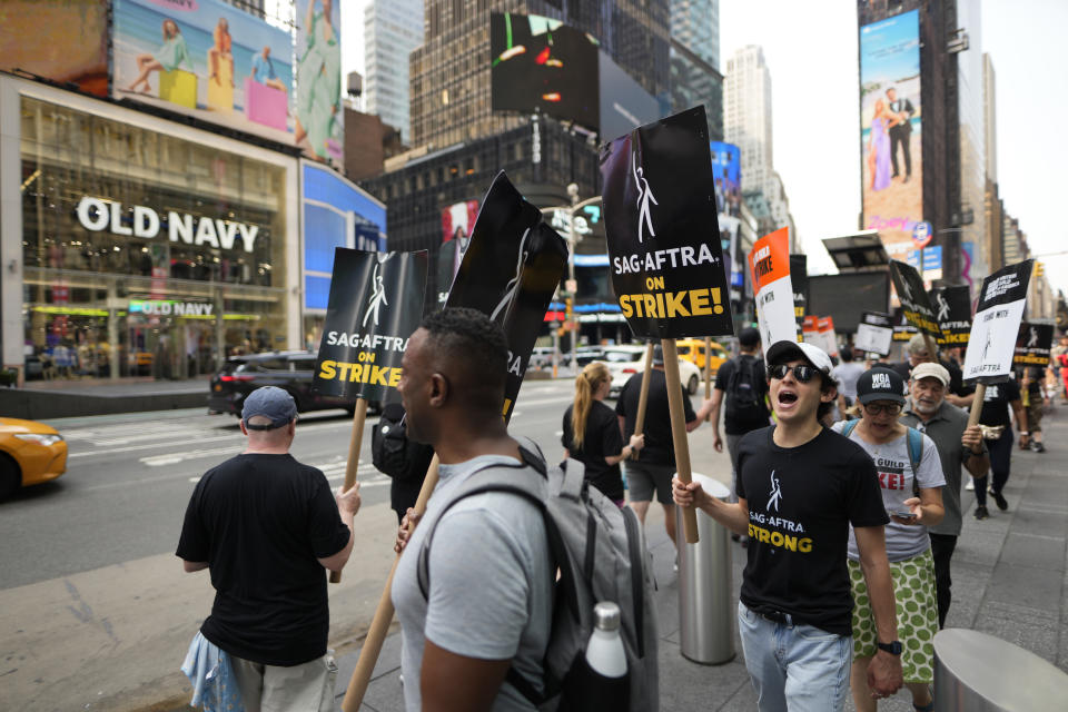 Picketers carry signs outside Paramount in Times Square on Monday, July 17, 2023, in New York. The actors strike comes more than two months after screenwriters began striking in their bid to get better pay and working conditions and have clear guidelines around the use of AI in film and television productions. (Photo by Charles Sykes/Invision/AP)