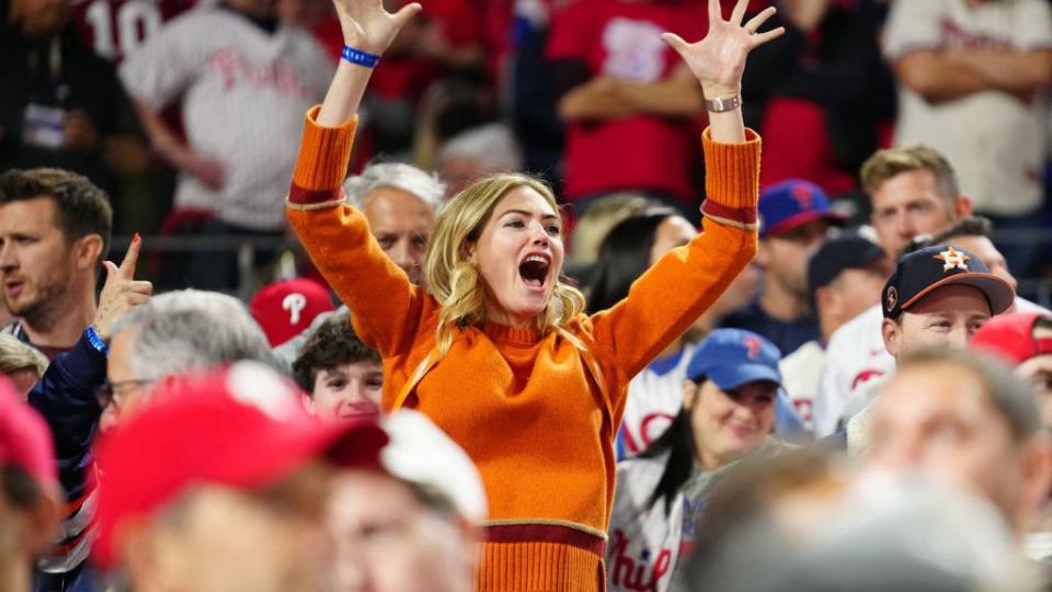 kate upton cheering with her arms in the air at world series game