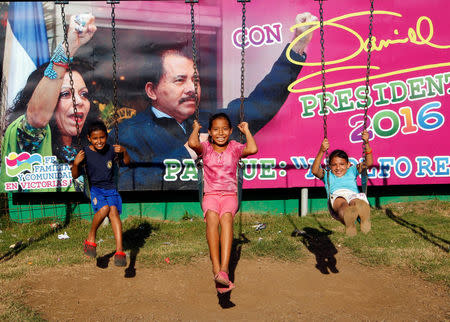 Children play in front of a campaign poster of Nicaragua's President Daniel Ortega and his vice presidential candidate, first lady Rosario Murillo at a playground in Managua, Nicaragua October 27, 2016. REUTERS/Oswaldo Rivas