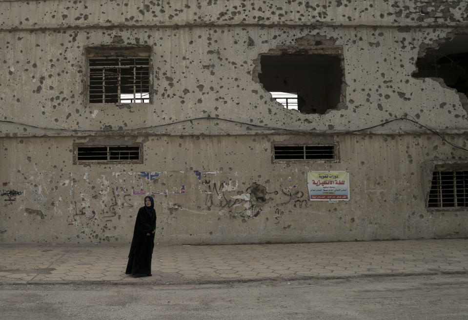 <p>A woman waits outside a heavily-damaged building near a polling site in west Mosul, Iraq, Saturday, May 12, 2018. (Photo: Maya Alleruzzo/AP) </p>