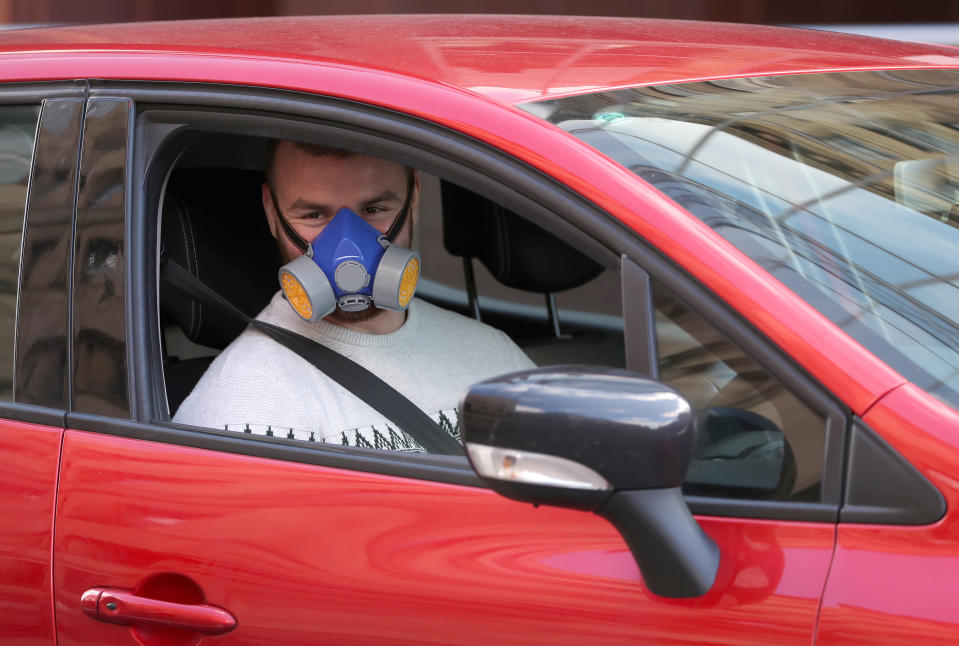 A motorist wearing a face mask drives through the streets of Glasgow as the UK continues in lockdown to help curb the spread of the coronavirus.