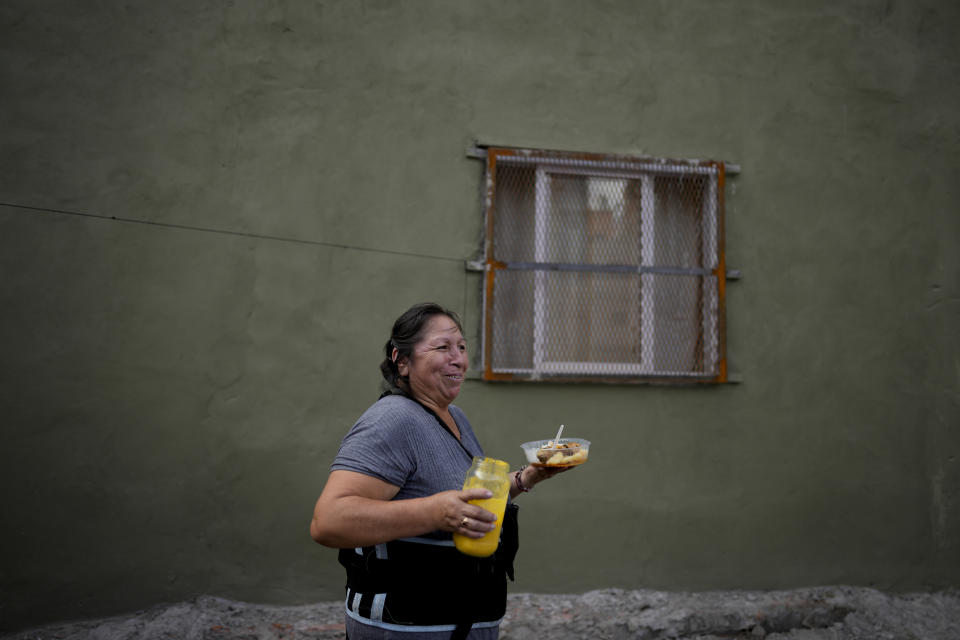 Street food vendor Margarita Vidal delivers a meal, amid rising inflation in Buenos Aires, Argentina, Thursday, March 16, 2023. (AP Photo/Natacha Pisarenko)