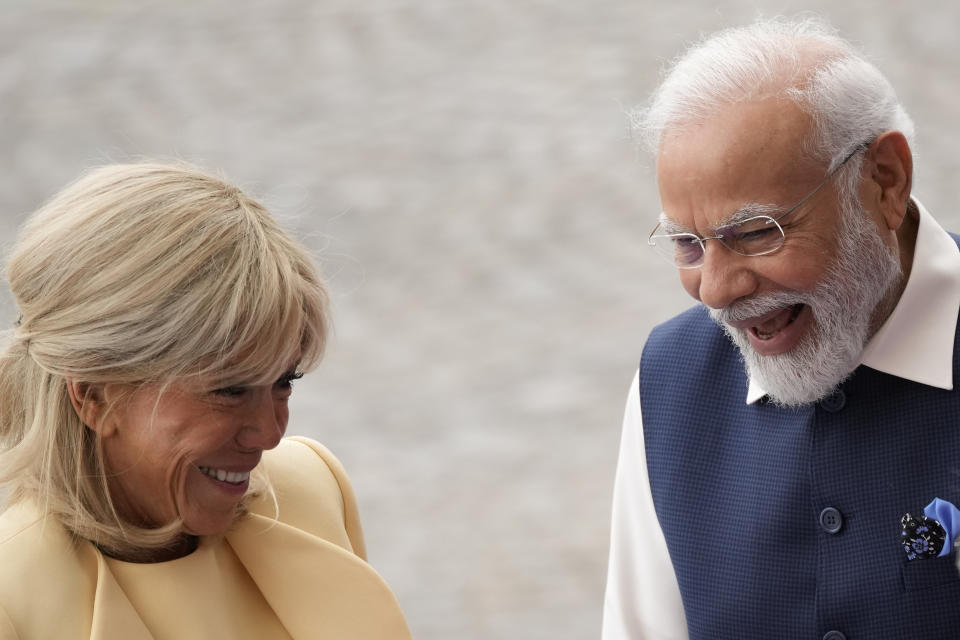 Indian Prime Minister Narendra Modi, right, smiles with French President's wife Brigitte Macron prior to the start of the Bastille Day parade on the Champs-Elysees avenue in Paris, Friday, July 14, 2023. (AP Photo/Christophe Ena)