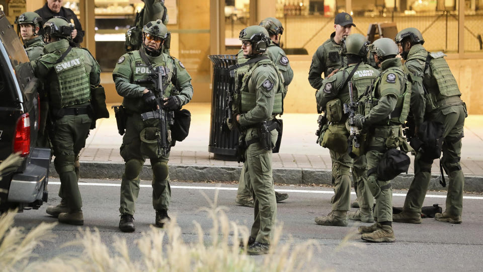 The Atlanta SWAT team stage in a street in Midtown Atlanta on Wednesday, Oct. 20, 2021. Police in Atlanta have closed streets around at least four square blocks of office and apartment buildings in response to gunfire in the city's midtown area. (John Spink/Atlanta Journal Constitution via AP)