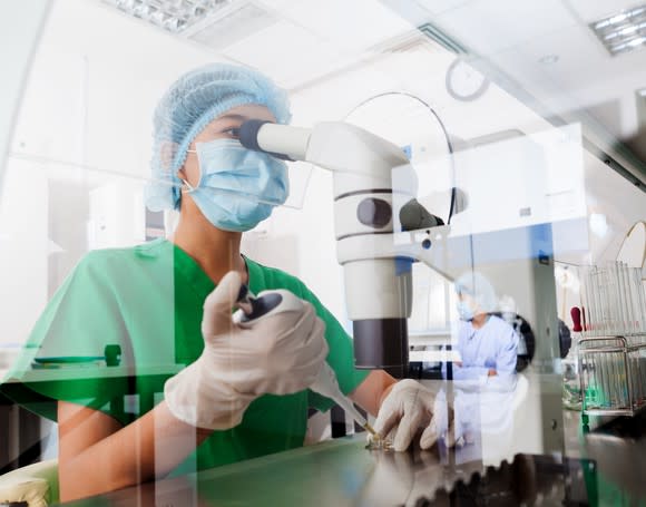 Scientist looking through a microscope.