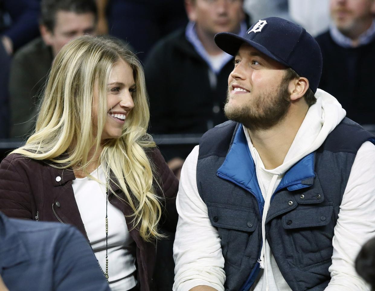 FILE - In this Nov. 17, 2015, file photo, Detroit Lions quarterback Matthew Stafford and his wife Kelly smile while watching the Detroit Pistons play the Cleveland Cavaliers during an NBA basketball game, in Auburn Hills, Mich. Matthew is juggling his job on the field and his role as a husband and father as his wife, Kelly, recovers from surgery to remove a brain tumor. (AP Photo/Duane Burleson, File)