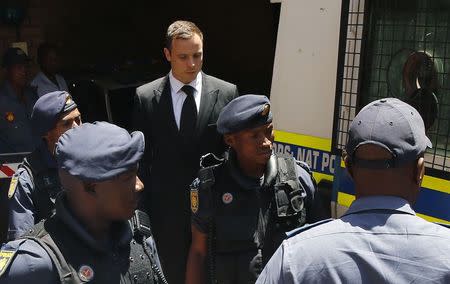 South African Olympic and Paralympic sprinter Oscar Pistorius (C ) is escorted to a police van after his sentencing at the North Gauteng High Court in Pretoria October 21, 2014. REUTERS/Siphiwe Sibeko