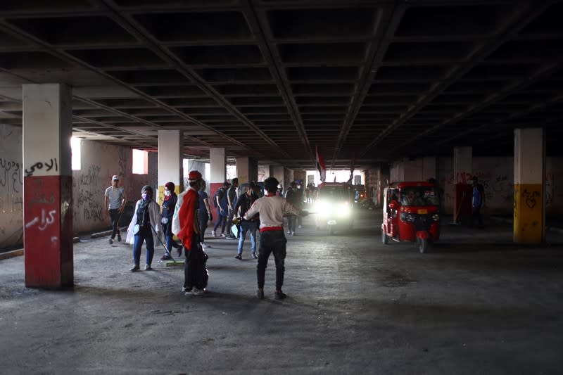 Iraqi demonstrators are seen inside the parking of the high-rise building, called by Iraqi the Turkish Restaurant Building, during anti-government protests in Baghdad