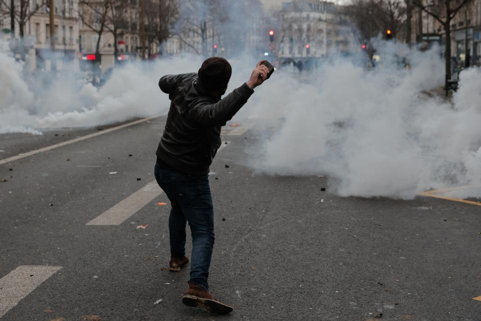 A demonstrator throws a stone at officers (AP)