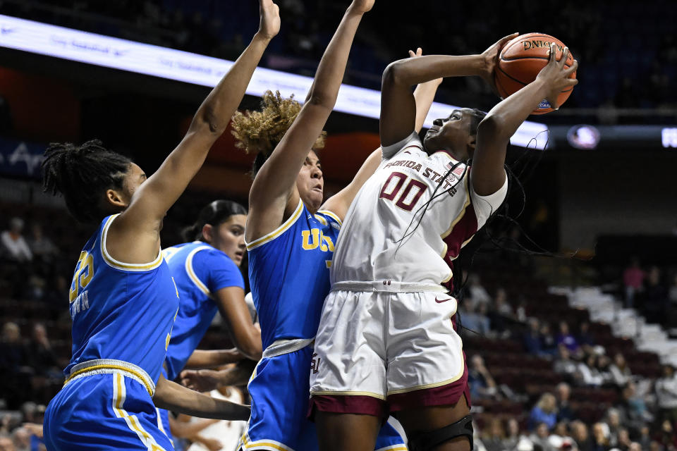 Florida State guard Ta'Niya Latson (00) shoots as Florida State guard Brianna Turnage defends in the first half of an NCAA college basketball game, Sunday, Dec. 10, 2023, in Uncasville, Conn. (AP Photo/Jessica Hill)