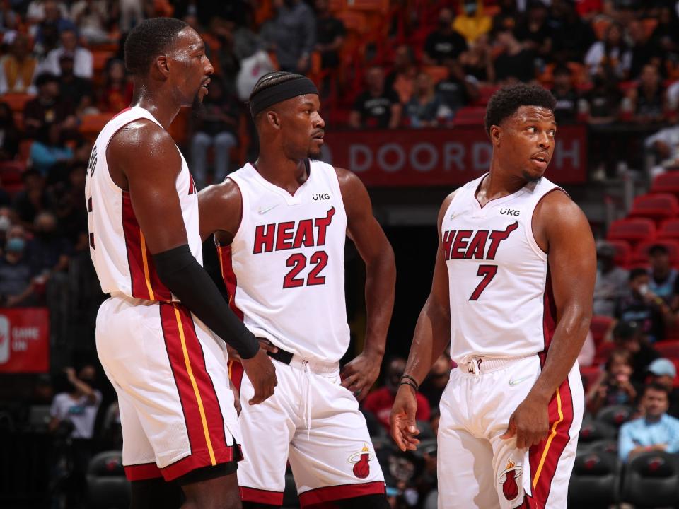 Bam Adebayo, Jimmy Butler, and Kyle Lowry stand next to each other during a Heat game in 2021.