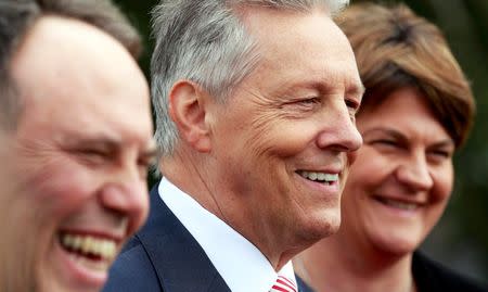 Democratic Unionist Party (DUP) leader Peter Robinson (C) is flanked by party colleagues as he reacts during a news conference in front of Parliament buildings in Stormont, Northern Ireland September 21, 2015. REUTERS/Cathal McNaughton