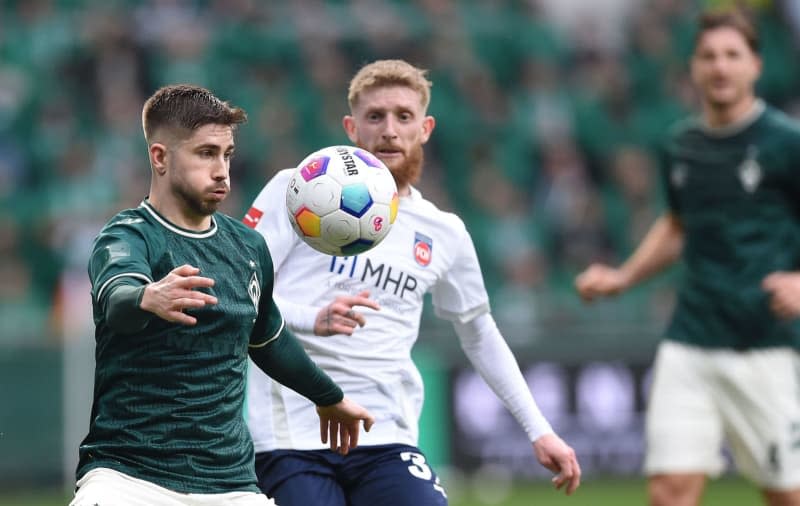 Werder Bremen's Romano Schmid (L) and Heidenheim's Jan-Niklas Beste battle for the ball during the German Bundesliga soccer match between Werder Bremen and 1. FC Heidenheim at Weser Stadium. Carmen Jaspersen/dpa