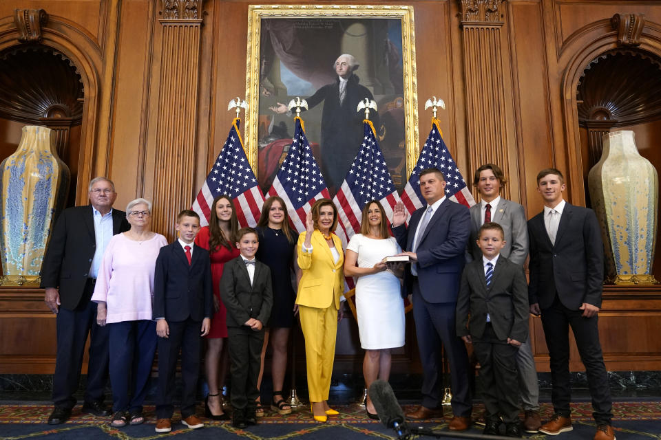 House Speaker Nancy Pelosi of Calif., center, conducts a ceremonial swearing-in for Rep. Brad Finstad, R-Minn., fourth from right, joined by his wife Jaclyn and their family, Friday, Aug. 12, 2022, on Capitol Hill in Washington. (AP Photo/Patrick Semansky)