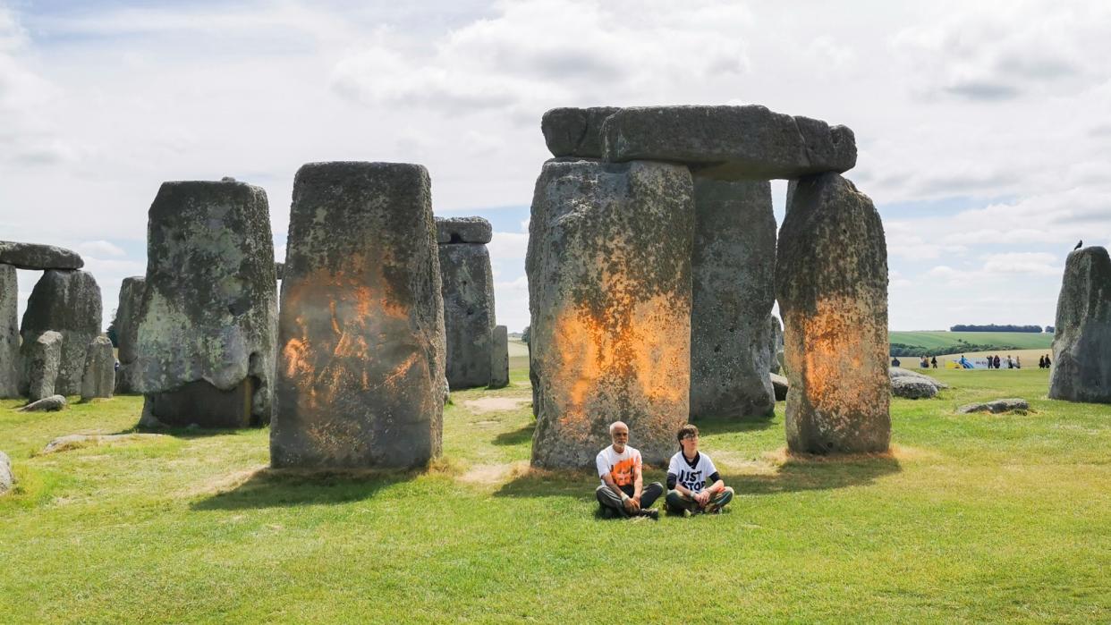  Protesters sit after spray painting the Stonehenge monument in England. 