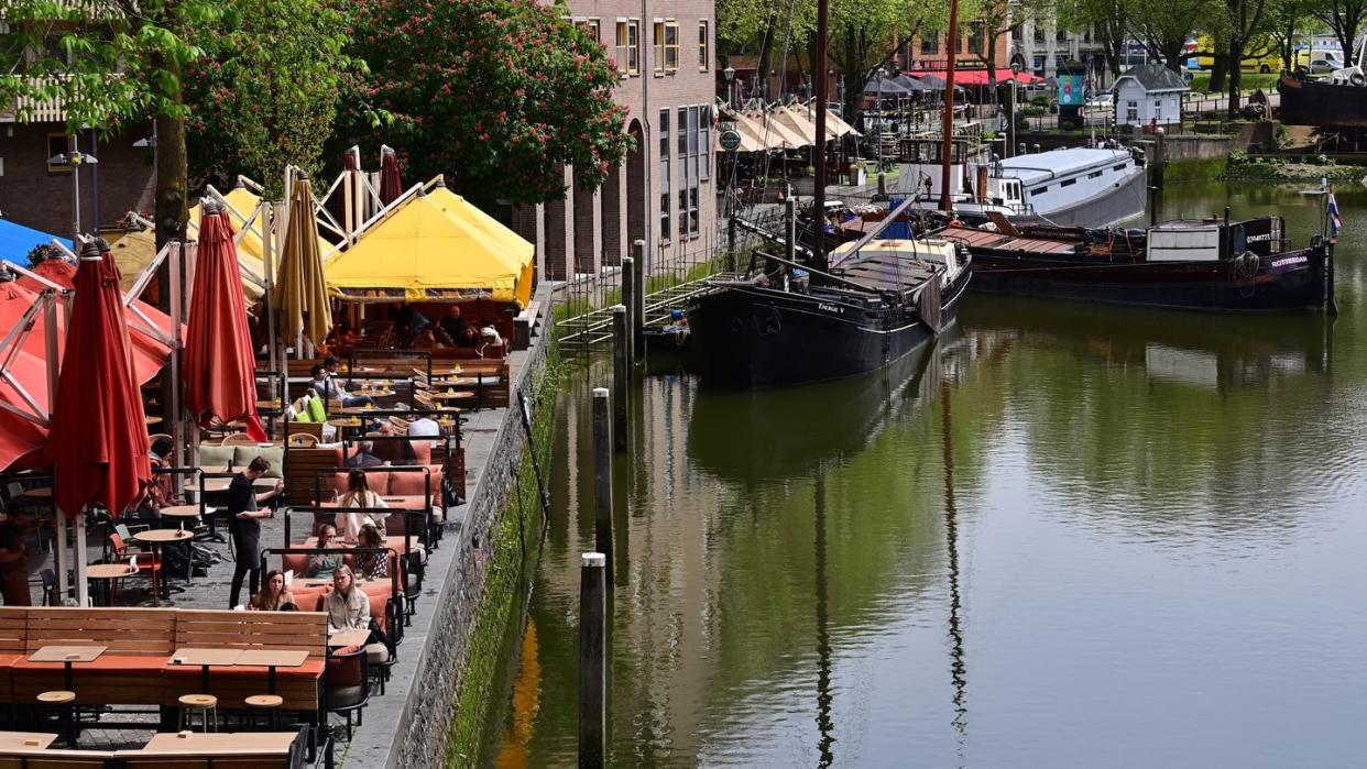 Nur wenige Gäste sitzen bei sonnigem Wetter in den Außenbereichen der Cafés und Restaurants am Historischen Hafen in Rotterdam (Archivbild).